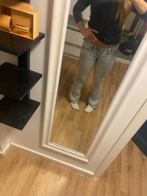 Ljusblå True religion jeans - Säljer ett par ljusblå True religion jeans med snygga broderade detaljer på bakfickorna. Jeansen har låg midja och klassisk femficksdesign. Perfekta för dig som gillar en avslappnad men trendig stil. Storlek w23 i joey och uppsydda till en person som är mellan 155-150 skulle jag säga köpta för 1300 