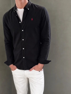Svart skjorta från Ralph Lauren - Säljer denna Ralph Lauren-skjorta. Modellen är 183 cm lång och väger 76 kg. Skriv gärna för fler bilder eller mått!