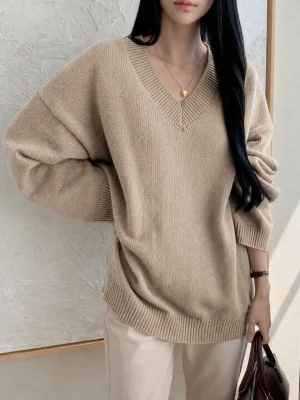 Beige oversized stickad tröja - Snygg beige stickad tröja med v-ringning och avslappnad, oversized passform. Tröjan har breda ribbade muddar vid ärmslut och nederkant. Perfekt att styla med jeans eller kjol för en trendig look.