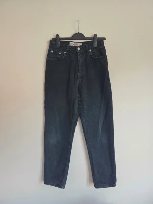 Vintage jeans från Davy’s Jeanswear – mörk denim - Säljer ett par snygga vintagejeans från Davy’s Jeanswear 💙  Jeansen har en fin mörk denimtvätt i en snygg blandning av svart, grått och mörkblått som ger en riktigt cool vintagekänsla ✨ Perfekta att styla med allt från en enkel topp till en oversized tröja.  👖 Märke: Davy’s Jeanswear 👖 Storlek: W30 L30 (mått längre ner) 👖 Modell: Rak passform 👖 Färg: Mörk denim / svart-grå med mörkblå toner 👖 Skick: Fint vintage skick med mycket kvar att ge 🤍  📏 Mått midja ca 35. Längd totalt: ca 100 cm