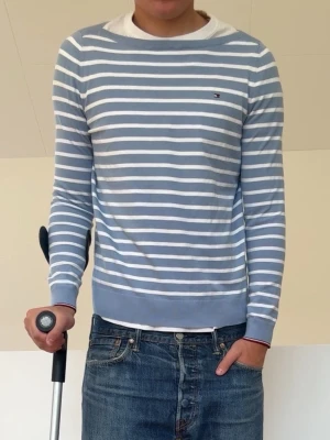 Ljusblå Randig tröja - Ljusblå Randig Tommy Hilfiger tröja i strl M men sitter som en S! Bra skick utan nåra defekter och hör gärna av er vid frågor elr funderingar!!