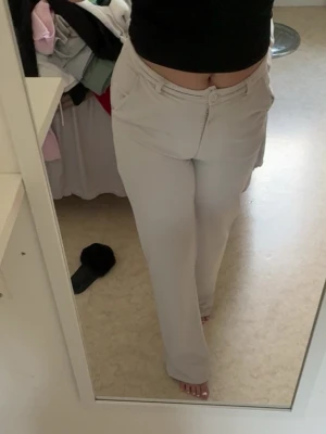 Beiga  kostymbyxor - Snygga beiga kostymbyxor med raka ben och hög midja. Byxorna är för långa för mig så jag har trampat på byxorna när jag har haft dom, men går att tvätta bort det. 