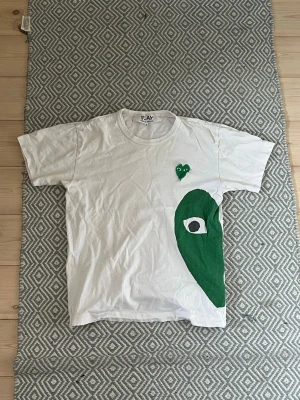 Play CdG T-shirt - En otroligt fin tisha från det välkända märket vid namn Comme des garçon. Denna tisha är i bra skick enligt mig. Pris får diskuteras på ett professionellt sätt. Dra gärna en linna vid intresse!