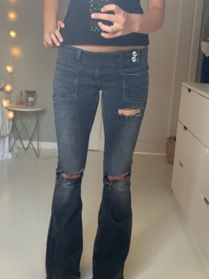Grå/ bootcut jeans från Gina tricot  - Säljer ett par grå/svarta bootcut jeans med slitningar över knäna och hål. Jeansen är köpta på Gina tricot 14+ i storlek S. Mycket fint skick. Perfekta till vardags och finare tillfällen! Skriv för frågor!💓💓