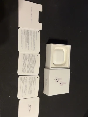 Apple AirPods med laddningsetui - Säljer ett par vita Apple AirPods med tillhörande laddningsetui och originalförpackning. Trådlösa hörlurar i stilren design, perfekt för musik, samtal och träning. Kommer med manualer och allt som syns på bilden.