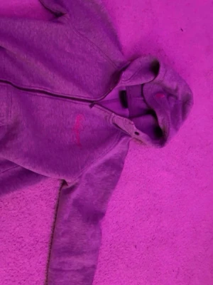Grå zip hoodie med huva - Säljer en grå hoodie med dragkedja och huva. Hoodien har långa ärmar och fickor framtill. Perfekt för chill dagar eller när du vill ha en enkel och snygg look. Materialet känns mjukt och bekvämt.