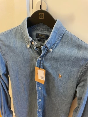 Ralph Lauren Skjorta  - Tja, säljer en helt ny Ralph Lauren skjorta i storlek S slim fit perfekt till sommaren. Skick 9/10 inga synliga defekter hör gärna av er vid minsta lilla fundering! 
