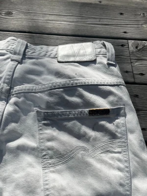 Nudie jeans straight fit - Storlek: W31/L32                                                                     Midja: 41,5cm, Benlängd: 107cm.      Feta jeans i cool vit färg från Nudie jeans. Schyssta i gott skick med lite slitningar längst ner på benen. Bra skick inga tydliga defekter✅ Hör av er vid frågor!      
