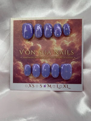 Sumire (M);ExtraShortOval  - Set handgjorda press-on naglar i en snygg lila pärlemorskimmrande färg med lila prickar. Naglarna har en extra kort oval form och en glansig finish som ger en trendig look. Perfekt för dig som vill ha unika och kreativa naglar utan att gå till salong.M: 16 mm, 12 mm, 12,5 mm, 11,5 mm, 10 mm