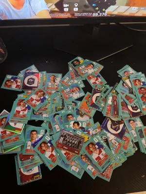 Stort paket fotbollsstickers - Säljer ett stort paket med fotbollssticker, ungefär 300-400 st. Från  panini 2026, olika lag och spelare. Stickersen har blå och turkosa kanter och visar fotbollsspelare i olika landslagströjor. Perfekt för samlare eller dig som vill byta med vänner. Obs! Kan ha flera av samma kort