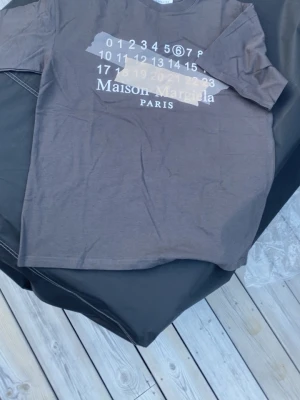 Maison marigela t shirt - En snygg mörkgrå Maison marigela t shirt i toppen skick. Den är i storlek S men passar även M. Hör av er vid funderingar, pris kan diskuteras vid snabb affär 👍