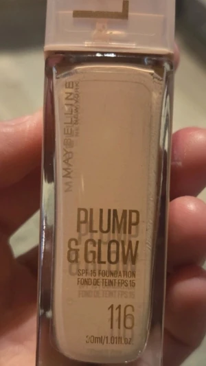 Maybelline Plump & Glow Foundation 116 - Foundation från Maybelline i nyansen 116. Ger en plumpande och glowig finish med SPF 15. Kommer i en rektangulär glasflaska med beige lock och guldtext. Innehåller 30 ml flytande foundation som passar för en naturlig look.