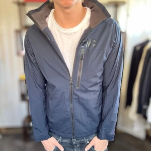 Helly Hansen windbreaker - Mycket fint skick, inga defekter. Nypris ca 2000kr. Passar dig som är 170-180cm ungefär. Modellen är 185 cm, 75 kg. Alltid billigare pris vid köp av flera varor‼️🙌Svarar alltid på frågor eller funderingar!  