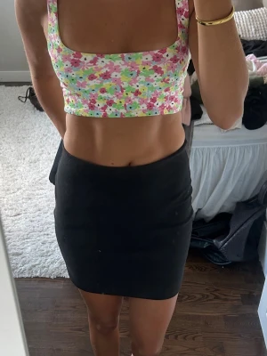 Blommig croppad linnetopp - Säljer en croppad linnetopp med blommigt mönster. Toppen har breda axelband och fyrkantig urringning 