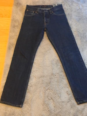 Nudie average Joe w29/l32 - Säljer dessa mörkblåa nudie jeans i modellen average Joe. Average Joe är en regular/bootcut modell! Stl är w29 och l32 Midja:38cm Längd:102cm Fotöppning:19cm De är i superbra skick. Hör av er vid funderingar