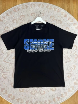 Pop Smoke x VLONE tshirt  - Storlek: L Färg: Svart Skick: Mycket bra  Pop Smoke x VLONE t-shirt med stort grafiskt tryck fram och stort V-motiv på baksidan. Svart modell med blått och lila motiv.  Se bilder för skick och detaljer.