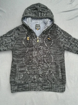 Kabelstickad hoodie - Snygg kabelstickad hoodie / cardigan i en fin färg. Fint skick. Storlek XXL, sitter som XL/L, man bör va 189+ för att den ska sitta bra. 