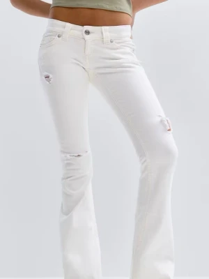 Helt oanvända Vita low rise jeans med slitningar - Säljer ett par snygga vita jeans med slitningar på låret och knät. Jeansen har utsvängda ben. Jeansen är helt oanvända jag råk köpa fel storlek och kunde inte lämna tillbaka.💕