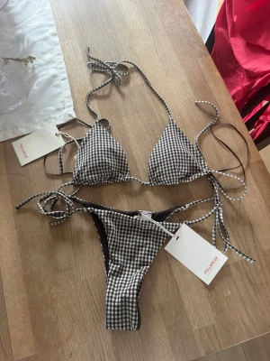 Svartvit rutig bikini från Pull&Bear - Helt ny alla lappar kvar! Överdel stl s underdel stl xs💕💕💕Trendig bikini från Pull&Bear med svartvitt rutigt mönster. Klassisk trekantsmodell upptill och knytband både på överdel och underdel. Materialet är mjukt och stretchigt, perfekt för stranden eller poolen. Snygg och ungdomlig design med smickrande passform.