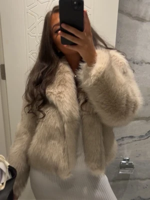 Beige fluffig pälsjacka - Säljer en supermjuk och fluffig beige pälsjacka med bred krage och långa ärmar. Helt ny och oanvänd! Jackan är i storlek 46 men passar även mig perfekt som har 36/38💕
