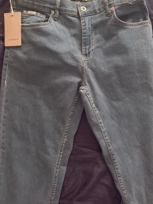 Ljusblå jeans från Lindbergh - Snygga ljusblå jeans från Lindbergh med klassisk femficksmodell och raka ben. Jeansen har ljusa kontrastsömmar och är tillverkade i ett mjukt denimtyg som ger en avslappnad look. Perfekta för dig som gillar stilrena och tidlösa jeans.