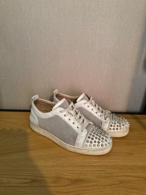 Christian Louboutin skor - Louis Junior Spikes med grå mesh på sidan som gör dom luftiga | Silvriga spikes men färgen bortnött längst fram | Skitiga på bild och går garanterat att tvätta upp snyggare | Självklart ÄKTA | Storlek 40 1/2 men sitter mycket större, passar 41/42 | Hör av dig vid frågor eller funderingar!
