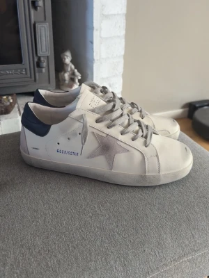 Golden goose skor  - Riktigt snygga golden goose skor i färgerna vit och marinblå som matchar perfekt med sina ikonsiksa slitningar, 
