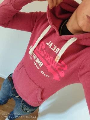 Superdry hoddie  - Fin röd superdry hoddie i väldigt bra skick modellen på bilden är 177cm och den passar bra, jag rekommenderar den varmt och bjuder in dig till mina andra annonser 😃