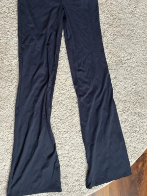 Marinblåa utsvängda leggings Gina Tricot - Säljer ett par marinblåa leggings från Gina Tricot i storlek 158/164. De har utsvängda ben och är gjorda i ett mjukt och stretchigt material som sitter skönt. Perfekta för dig som gillar en enkel men trendig look.