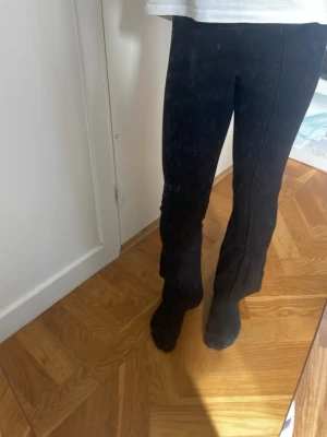 Svarta raka byxor med slits - Snygga svarta byxor med rak passform och slits nertill på benen. Byxorna har en enkel och stilren design som passar till många olika looks. Tillverkade i ett mjukt material som ger en bekväm känsla hela dagen.