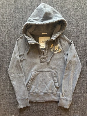 Abercrombie & fitch hoodie ~ YK2 - Sjukt eftertraktad Abercrombie & Fitch hoodie ~ sjukt sällsynt vintage modell | st S | färg grå | snyggt sliten design som ger en naturlig vintagekänsla | klassisk passform | sällsynt 2000’s modell | OBS kan gå ner lite i pris vid snabb affär! 🏄