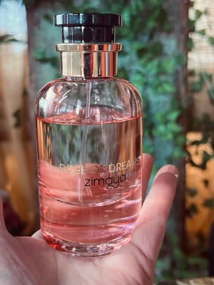  Zimaya Rose of Dreams; 100ml - Rose of Dreams från Zimaya är en parfym i en elegant, rund glasflaska med rosa doftvätska. Flaskan har guldfärgade detaljer och svart spraykork. Perfekt för dig som gillar blommiga och fräscha dofter. Cirka 85% kvar 
