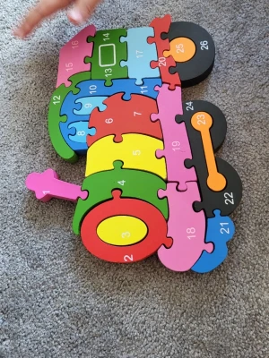 Färgglad träpussel traktor - Säljer ett färgglatt pussel i trä som föreställer en traktor. Pusslet har 26 bitar i olika färger och varje bit är numrerad från 1 till 26. Perfekt för att lära sig siffror och färger på ett roligt sätt. På baksidan är det bokstäver. 