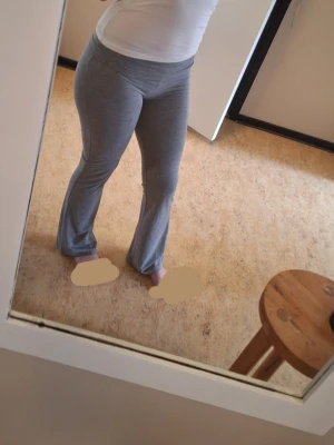 Grå mjukisbyxor med utsvängda ben - Grå leggings med bootcut-modell och anpassningsbar midja. Tillverkade i ett mjukt och stretchigt material som sitter bekvämt och följer kroppen. Perfekta för en chill och trendig stil.