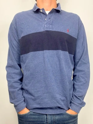 Polo Ralph Lauren Pikétröja  - Snygg Polo Ralph Lauren tröja. Perfekt tröja till ett par ljusare byxor! Blåmelerade färg med en marinblå rand och snygga unika armbågslappar ger tröjan en riktigt go look och karaktär. 🧵 Märke: Polo Ralph Lauren 📏 Storlek: M. Klassisk passform. 🧩 Material: 100% Bomull 📐 Mått: Axel: 48 cm. Bröst: 56 cm. Ärm: 67 cm. Längd: 73 cm. ✅ Skick: 9/10. Fint skick, sparsamt använd. Inga defekter!  🧍‍♂️ Modellen är 189 cm (dubbelkolla måtten ovan för att avgöra) 💰 Nypris: Ca 1400 kr ‼️ Skickas inom 24h‼️