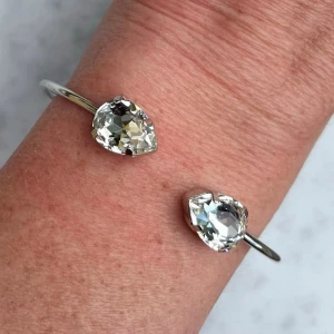 Armband Bangle kristall - Armband, Bangle, i silverpläterad mässing med kristaller. Kristaller Pear 14mm. Färg Clear Crystal, ställbar storlek. De senare bilderna andra armband som finns i lager. Jag skickar endast spårbart, samfraktar. Fast pris. Besök gärna mina övriga annonser.  Till mina smycken använder jag kristaller från Preciosa, Aurora och Swarowski.