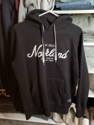 The Great Norrland hoodie - Säljer en svart The Great Norrland hoodie. Tröjan har huva med vita dragsnören och ribbade muddar vid ärmar och nederkant. 💗Storlek XXS men är större i storleken