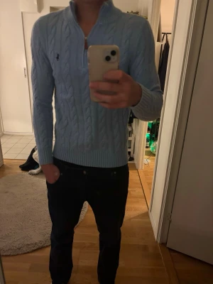 Ljusblå halfzip tröja Polo Ralph Lauren - Snygg ljusblå halfzip tröja från Polo Ralph Lauren med halv dragkedja och hög krage. 