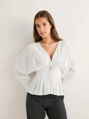 Vit v-ringad blus med veck - Säljer en stilren vit blus med djup v-ringning och knappar framtill. Blusen har långa, luftiga ärmar och markerad midja med fina veckdetaljer nedtill💕💕 skicka gärna prisförslag!!