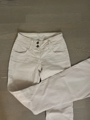 Vita bootcut jeans med hög midja - Snygga off-white jeans med bootcut ben och låg midja. Jeansen har dubbla knappar i midjan, nypris ca 800kr från Subdued