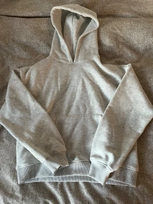Ljusgrå basic hoodie med huva - En stilren ljusgrå hoodie med huva och magficka. Tillverkad i mjukt sweatshirtmaterial med ribbade muddar vid ärmslut och nederkant. jätte skön 🩶
