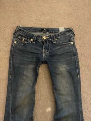 True Religion jeans - Säljer ett par blå low rised jeans från True religion. dem har gula sömmar och Använt få gånger. Skriv om ni vill ha fler bilder💞