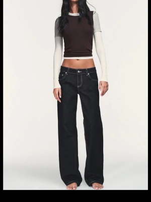 Svart/Mörkblå raka jeans med kontrastsömmar - Snygga jeans med raka ben och tydliga vita kontrastsömmar. Jeansen har klassisk femficksdesign och låg midja. Perfekta för en trendig och avslappnad look. NY MED PRISLAPP. 