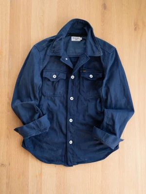 Tiger of Sweden Navy Overshirt, size S - Stilren mörkblå overshirt från Tiger of Sweden Jeans med två bröstfickor och vita knappar. Skjortan har klassisk krage och är tillverkad i ett mjukt bomullstyg. Perfekt lager-på-lager-plagg för en avslappnad look.
