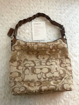 Coach 2007 Chelsea Optic Signature LG Hobo handbag - Coach Vintage (2007) bag in excellent condition, model: "Coach Chelsea Optic Signature LG Hobo". Has not been used much. In very good condition, both inside and out. The interior is completely clean, and the fabric is in excellent shape. There are some rust on parts of the metal hardware. You can find more photos of the bag on Vinted! ✨