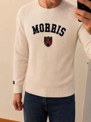 Vit stickad tröja från Morris - Säljer en stilren vit stickad tröja från Morris med text och emblem på framsidan. Tröjan har långa ärmar och en rund halsringning. Perfekt för en klassisk och avslappnad look.