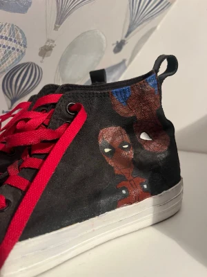 Spiderman converse - Storlek 41. Handmålade med lack så bör hålla. Oanvända av mig. Målade av mitt ex. 