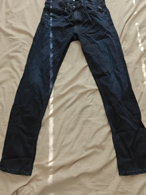 Replay jeans - Säljer ett par mörkblå jeans med rak passform och klassisk femficksdesign. Jeansen har normal midja och är tillverkade i ett denimtyg som känns slitstarkt. Perfekta för dig som gillar en enkel och stilren look.
