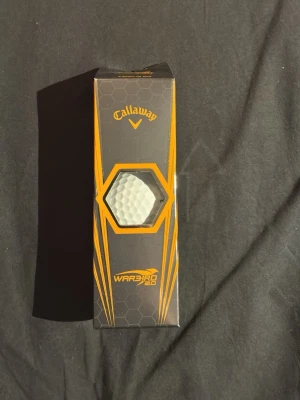 Golfbollar Callaway och färgade - Säljer ett paket Callaway Warbird 2.0 golfbollar samt en ask med 12 återvunna färgade golfbollar i orange och grönt. Perfekt för dig som vill ha synliga bollar på banan och gillar att variera spelet med olika färger.