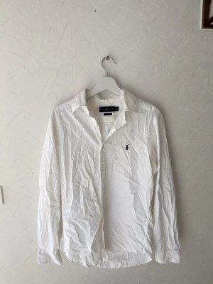 Ralph Lauren vit skjorta Slim Fit – M - Vit Ralph Lauren skjorta i storlek M, Slim Fit. Klassisk modell med mörkblå Ralph Lauren-logga på bröstet. Väldigt snygg både till vardags och mer uppklätt. I mycket bra skick utan några kända defekter. Skriv vid frågor eller om du vill ha fler bilder/mått 🙌